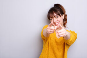 Portrait of cheerful young woman pointing finger at you. PayPal payment integration
