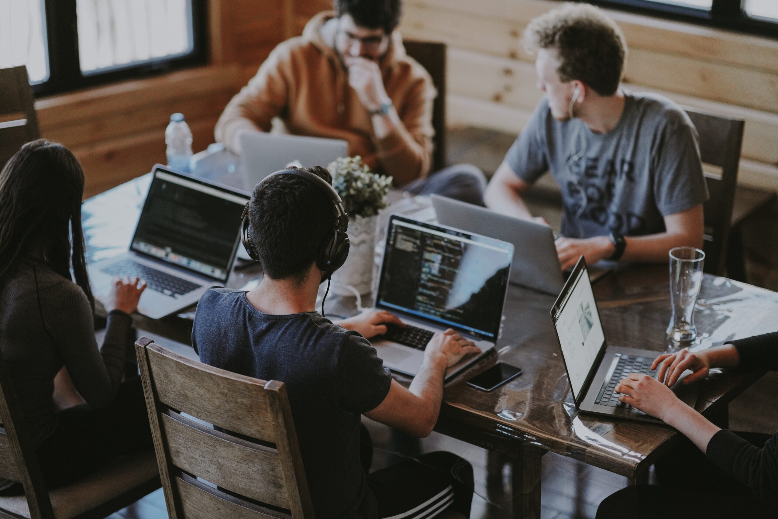 Employees sitting around a table on their laptops