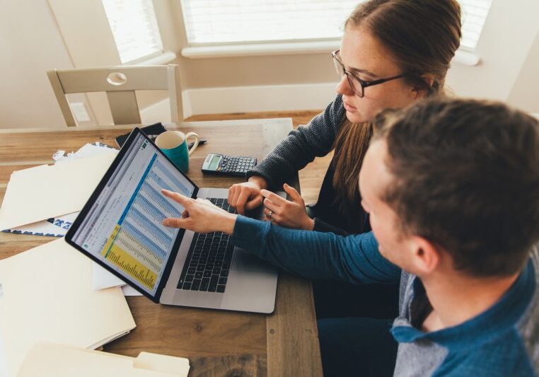 woman and man working on a spreadsheet on their computer