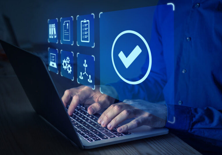 Quality management with QA (assurance), QC (control) and improvement. Standardisation and certification concept. Compliance to regulations and standards. Manager or auditor working on computer.