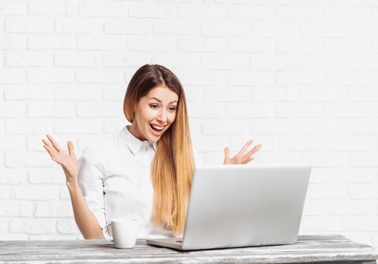Young surprised businesswoman using laptop computer