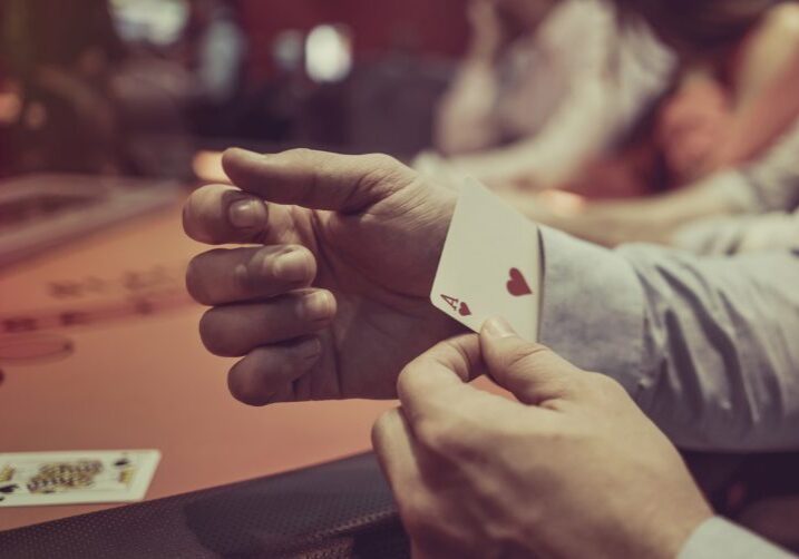 Close-up on a man hiding an ace under in his sleeve while playing poker at the casino
