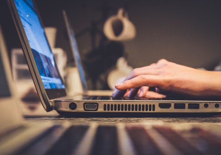 Hands typing on a laptop