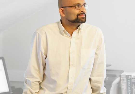 stuart-leaning-on-desk-1024x491